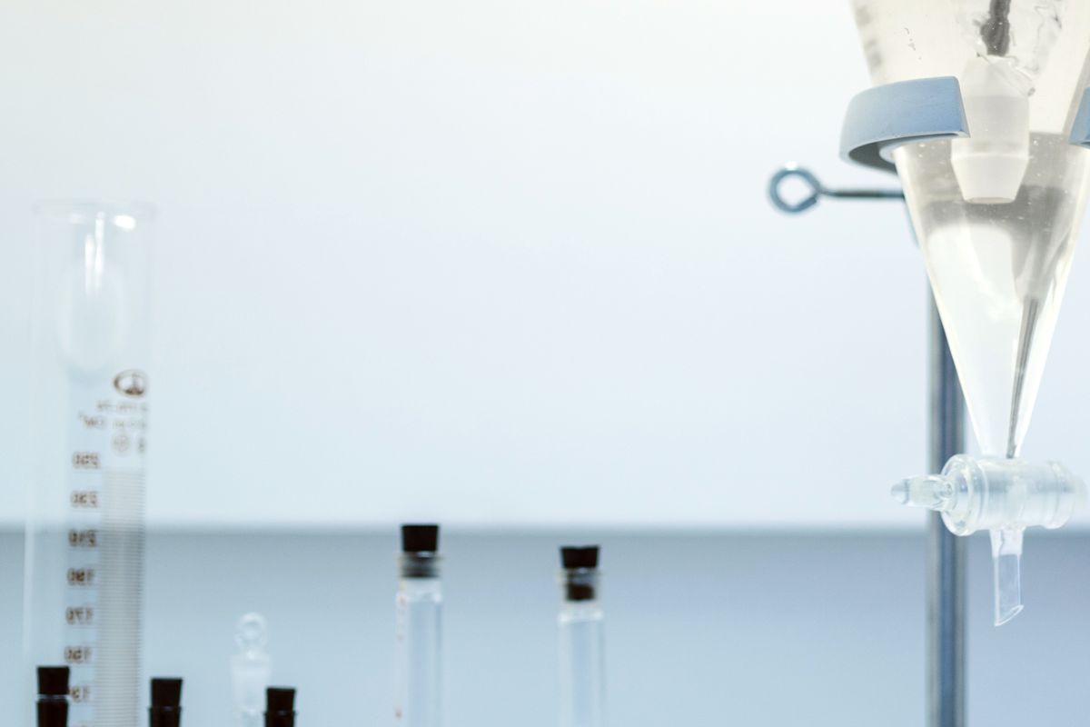 Laboratory glassware holding coloured liquids on a bench