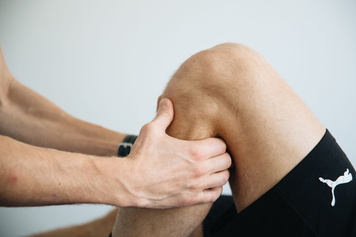 A therapist working on a patient's knee