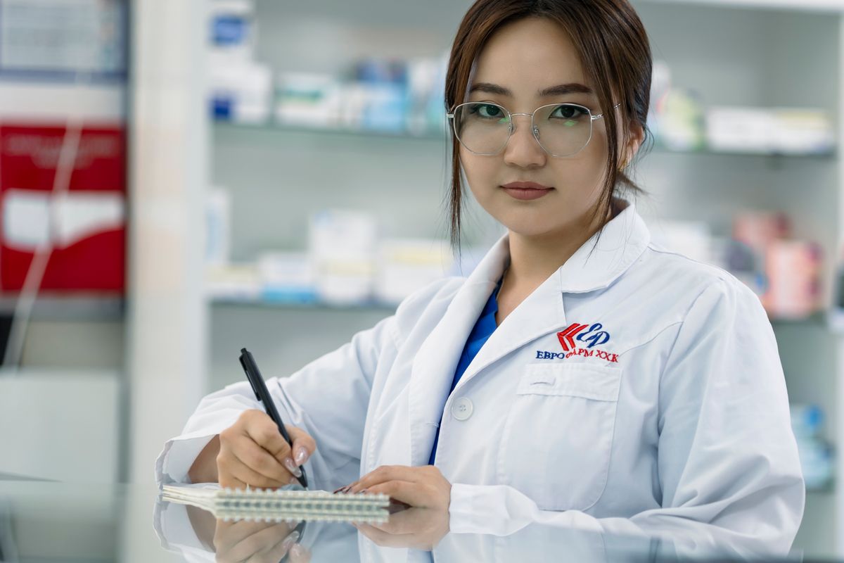 A pharmacist writing notes in a pharmacy