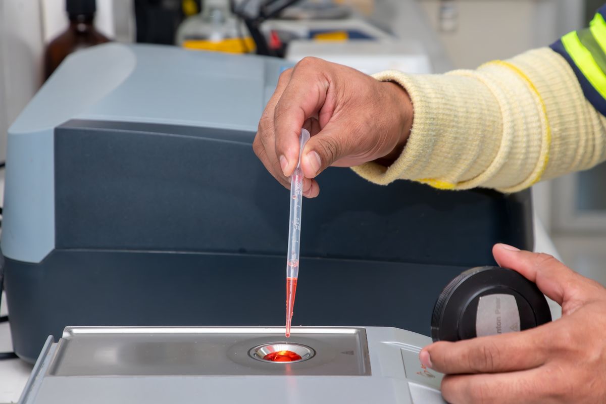 A laboratory technician using a pipette to transfer a precise volume