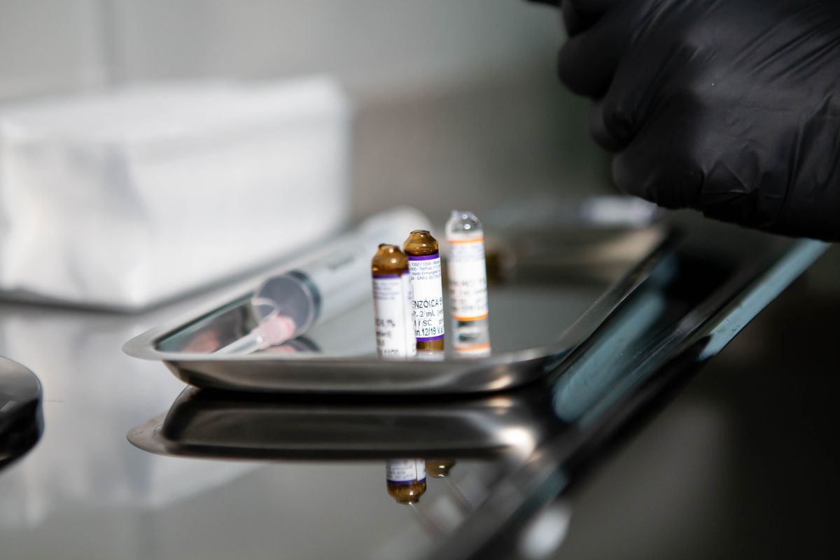 Medical vials and a syringe arranged on a stainless steel tray